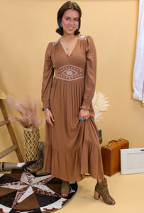 Model is wearing the Logan dress with western inspired accessories and a western inspired backdrop. 