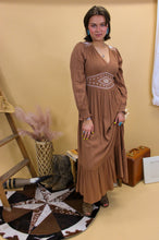 Load image into Gallery viewer, Model is wearing the Logan dress with western inspired accessories and a western inspired backdrop. 
