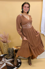 Load image into Gallery viewer, Model is wearing the Logan dress with western inspired accessories and a western inspired backdrop. 
