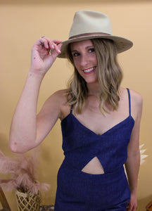Model is wearing the Brooke Jumpsuit and is in front of the western style backdrop. 