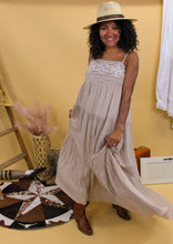 Load image into Gallery viewer, Model is wearing the Mae dress in front of the western inspired backdrop. 
