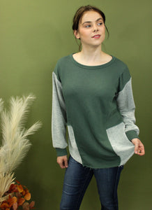 Model is wearing a green and grey colorblock long sleeve top 