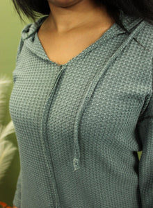 Model is wearing a green waffle knit hoodie.
