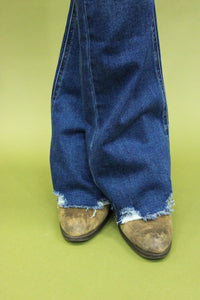 Model is wearing dark wash boot cut jeans. 