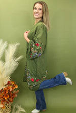 Load image into Gallery viewer, Model is wearing a green kimono with red and blue embroidered florals.
