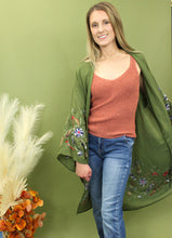 Load image into Gallery viewer, Model is wearing a green kimono with red and blue embroidered florals.
