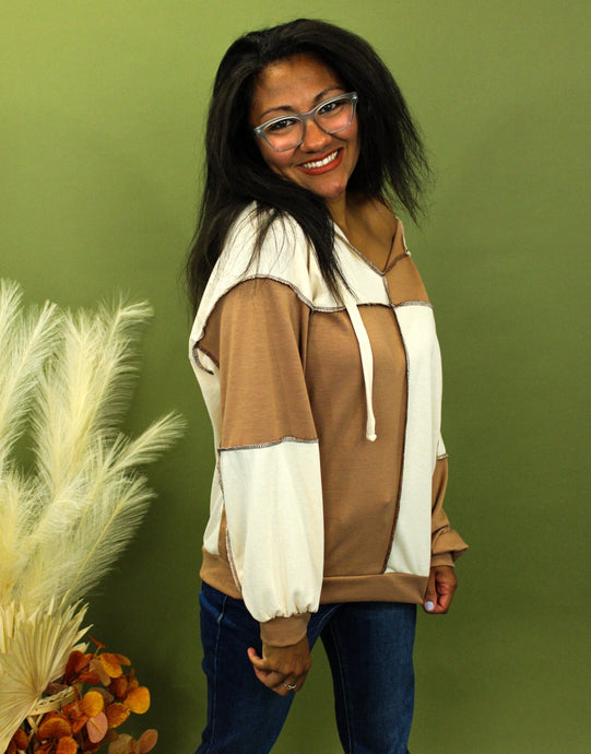 Model is wearing a cream and taupe color block sweatshirt. 