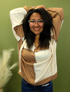 Model is wearing a cream and taupe color block sweatshirt. 