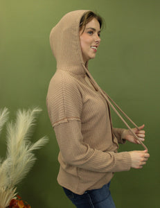 Model is wearing a camel waffle knit hoodie.