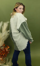 Load image into Gallery viewer, Model is wearing a green, teal, and cream color block shacket in front of a fall themed backdrop. 
