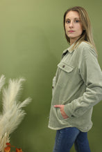 Load image into Gallery viewer, Model is wearing a moss green corduroy jacket in front of a fall backdrop 
