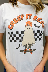 Model is wearing a graphic tee shirt featuring a ghost riding a skateboard. 