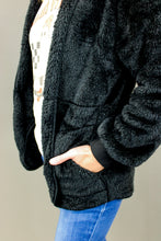 Load image into Gallery viewer, Model is wearing a black cozy cardigan. 
