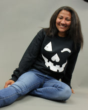 Load image into Gallery viewer, Model is wearing a black crew neck sweatshirt with a jack o lantern graphic. 

