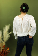 Load image into Gallery viewer, Model is wearing a white open knit sweater. 
