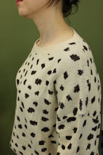 Load image into Gallery viewer, Model is weairng a cream color crew neck sweater with brown cheetah inspired print. 
