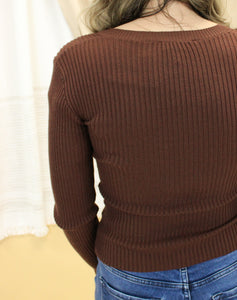 Model is wearing a brown rib knit sweater. 