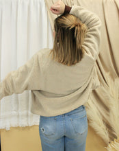 Load image into Gallery viewer, Model is wearing a neutral color sherpa jacket in front of a neutral backdrop. 
