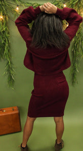 Model is wearing a burgundy sweater and sweater skirt set. 