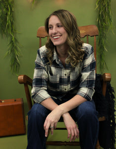 Model is wearing a navy button up top. 