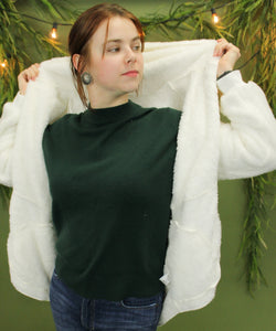 Model is wearing a white cozy cardigan. 