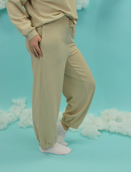 Model is wearing a beige lounge set. 