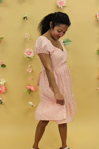 Model is wearing a peach floral dress. 