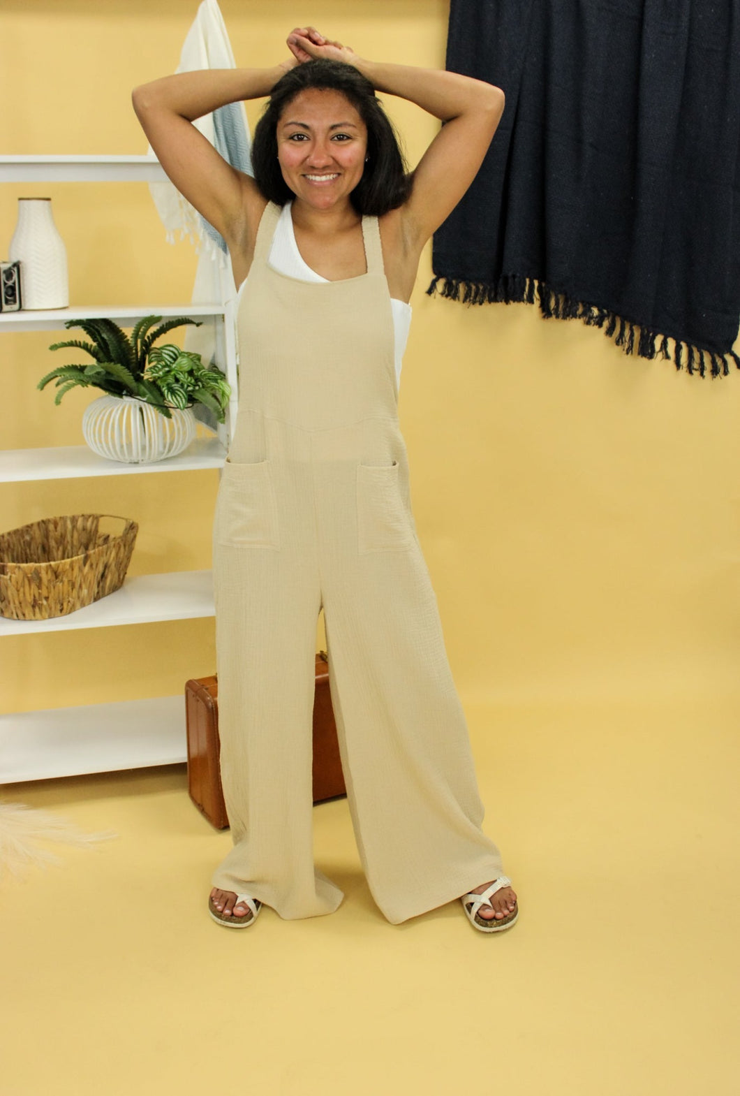 Model is wearing a beige jumpsuit. 