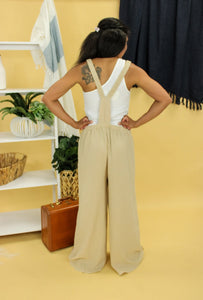 Model is wearing a beige jumpsuit. 