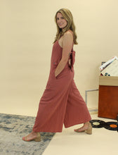 Load image into Gallery viewer, Models are wearing a brick colored jumpsuit. 
