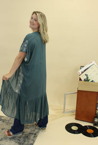 Model is wearing a blue and white embroidered kimono. 