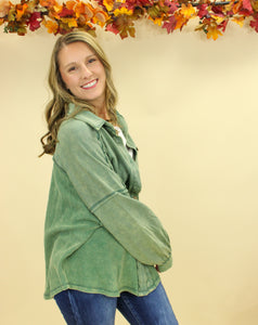 Model is wearing a green shacket. 