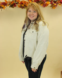 Model is wearing a cream color corduroy jacket. 