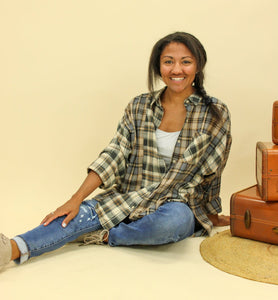 Model is wearing a plaid oversized button up shirt. 