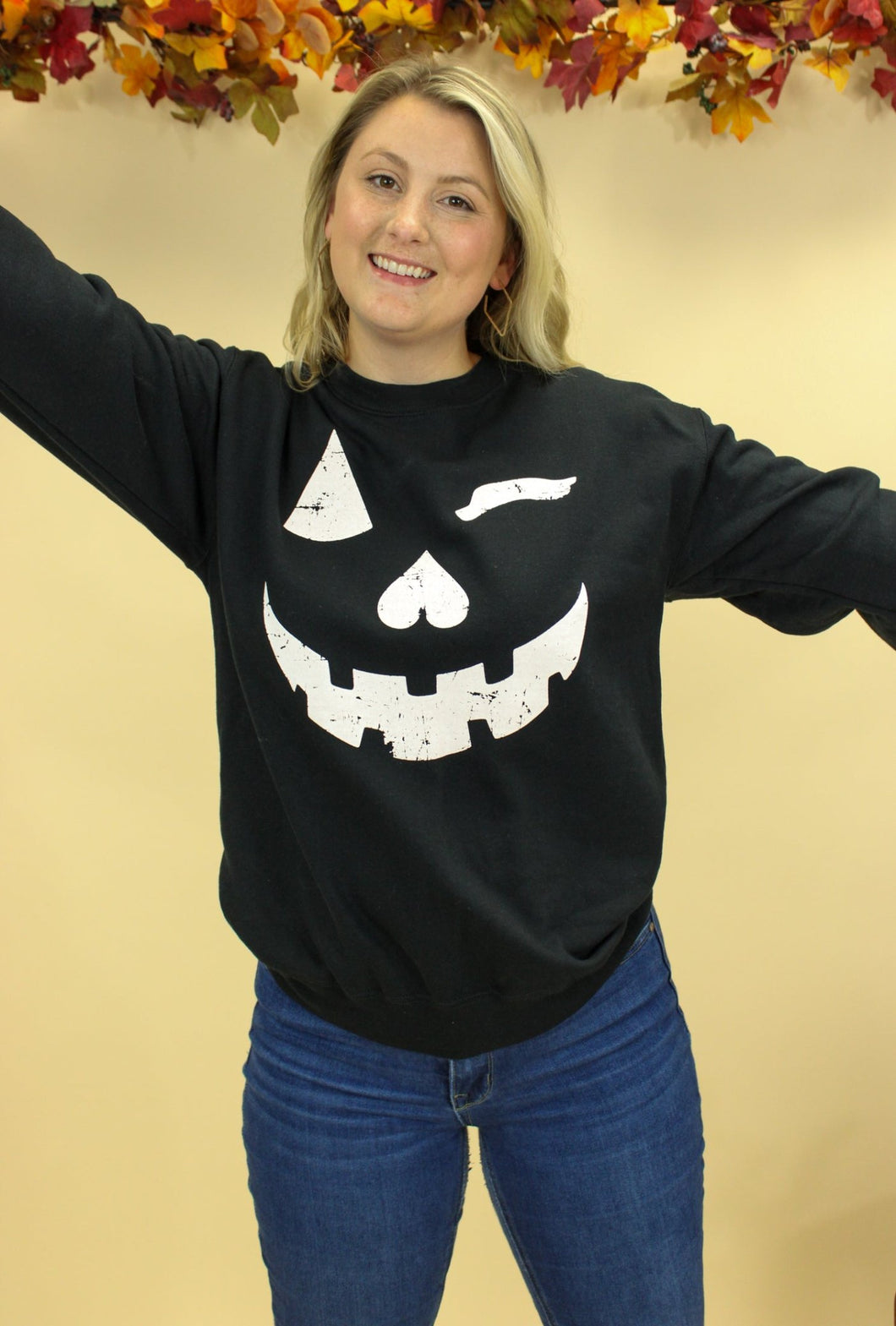 Model is wearing a Jack o lantern inspired sweatshirt