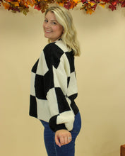 Load image into Gallery viewer, Model is wearing a black and white checkered sweater. 
