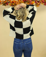 Load image into Gallery viewer, Model is wearing a black and white checkered sweater. 
